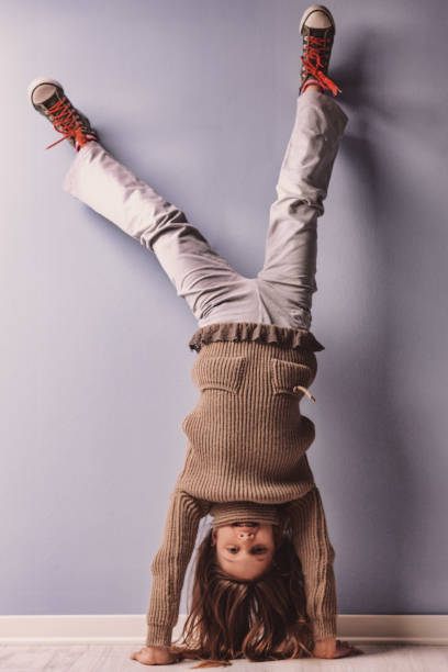 istock Young girl doing a handstand against a wall, showing playfulness and skill 2186229151