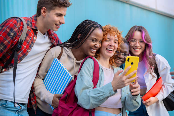 istock Five students having fun with mobile phones creating content on social media. 2186231484