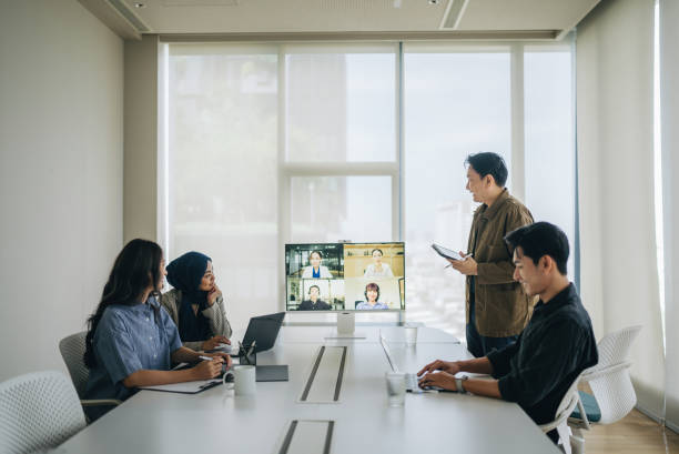 istock co-workers sitting in the meeting room and having a videoconference call with colleagues 2186233377