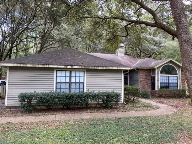 istock Old siding and cedar window trim on 1980's wood frame home, with limited rain gutters causing stains on flashing 2186233459