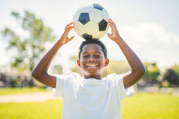 istock Young kid playing soccer on a playfield 2186240085