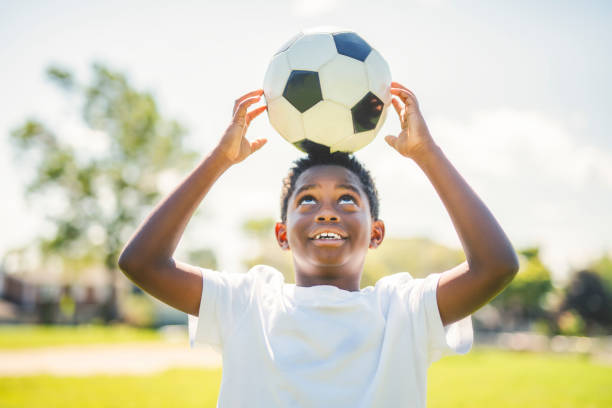 istock Young kid playing soccer on a playfield 2186240120