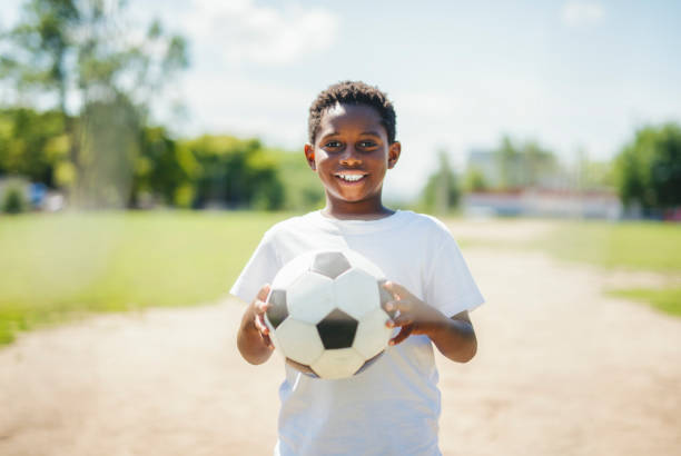istock Young kid playing soccer on a playfield 2186240176
