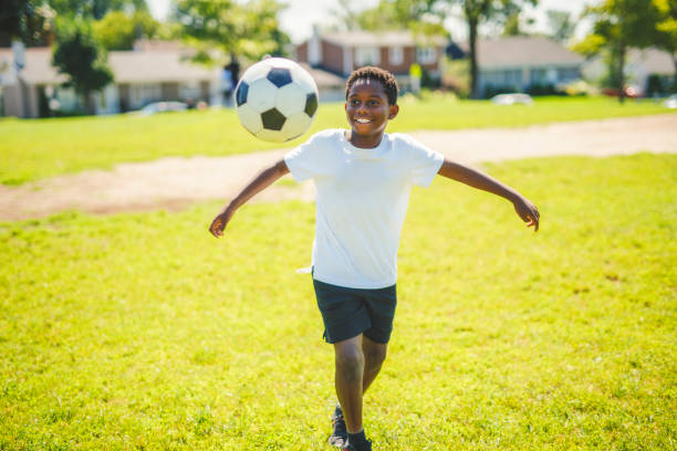 Little African - American boy playing soccer