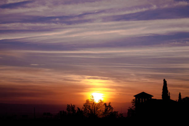 Photograph of a sunset where objects and nature are seen backlit.