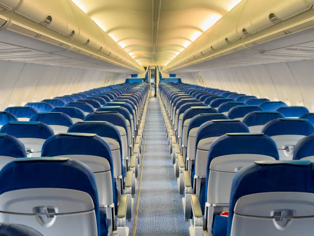 istock Interior rear view of empty aircraft aisle with passenger cabin seats 2186242392