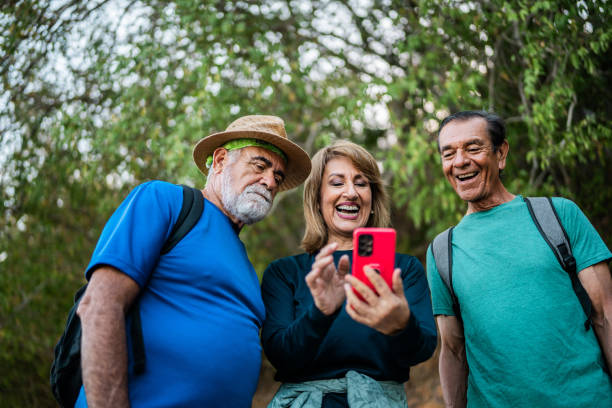 istock Senior friends talking and using mobile phone during hiking outdoors 2186250989