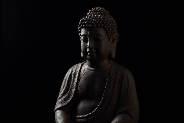 Meditating Buddha Statue on dark background. Close up. Copy space.