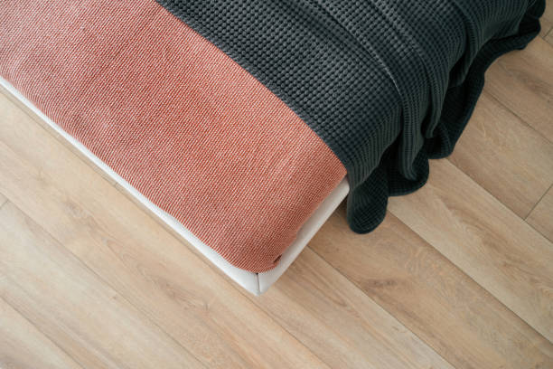 istock Cozy bed with textured blankets in a well-lit modern room 2186251788