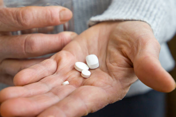 istock An old woman holds pills in her hands. Close up view. 2186253232