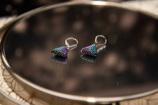 istock colored beaded earrings on a mirror background 2186253866