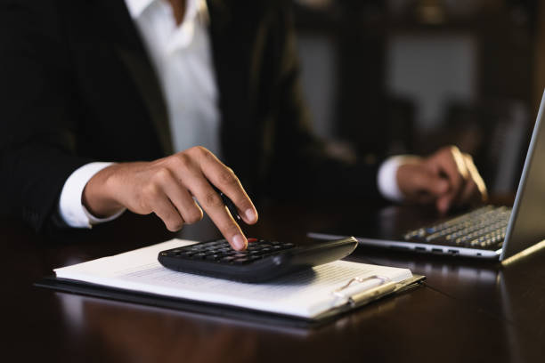 istock Businessman calculating finances using calculator and laptop in office 2186260924