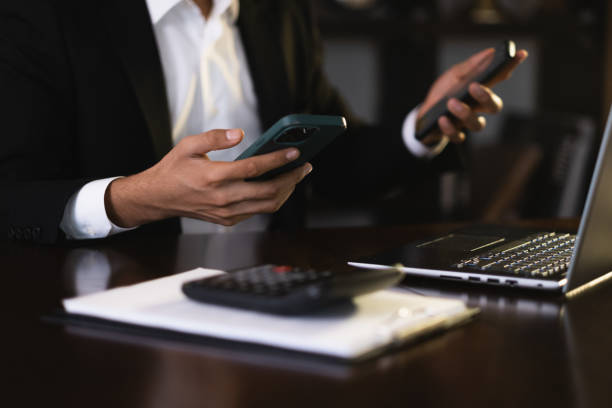 istock Businessman using two smartphones and laptop in office 2186260931