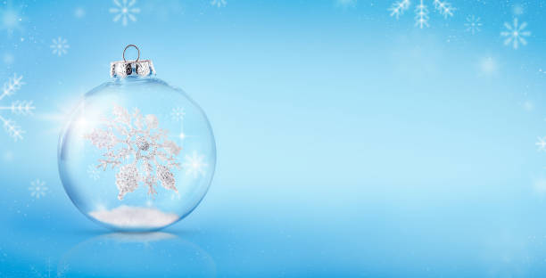istock Transparent Christmas tree ball with a snowflake floating inside on a light blue background. Copy space 2186273317