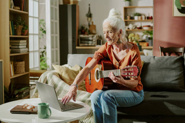 istock Elderly Woman Playing Guitar While Looking at Laptop 2186277632