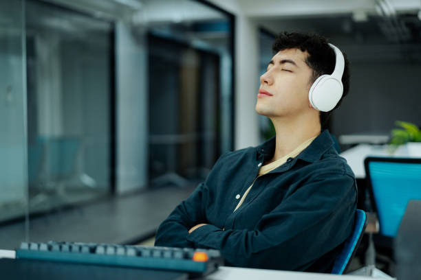 Relaxed Man Enjoying Music Through Headphones in a Modern Office Setting