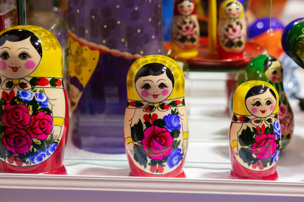 Detailed nesting dolls are arranged sequentially inside a decorative base, showcasing intricate designs and vibrant colors. The setting emphasizes artistry and cultural heritage.