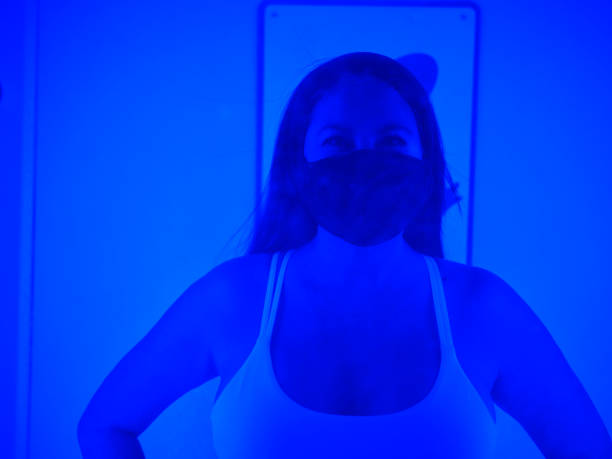 An adult woman in a cryotherapy chamber in a biohacking lab.