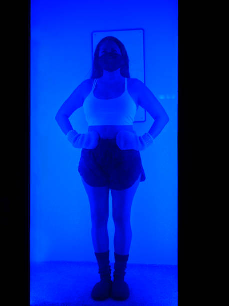 An adult woman in a cryotherapy chamber in a biohacking lab.