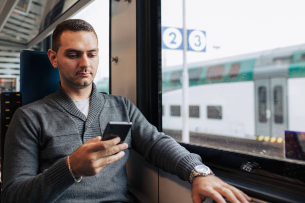 istock Young Man Using Smartphone While Traveling on Train for Business 2186289047