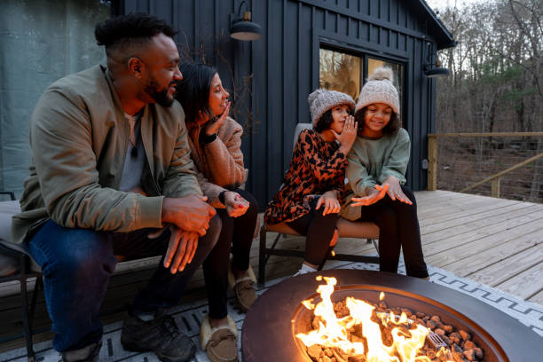 istock family in front of firepit relaxing in mountain house 2186306376