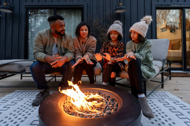 istock family in front of firepit relaxing in mountain house 2186306417