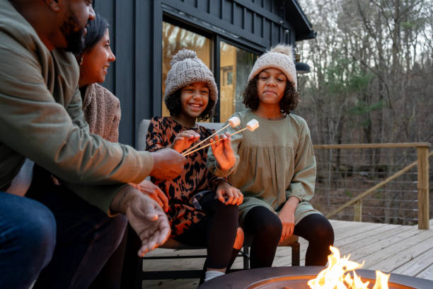 istock family in front of firepit relaxing in mountain house 2186307040