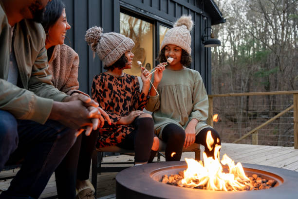 istock family in front of firepit relaxing in mountain house 2186307110