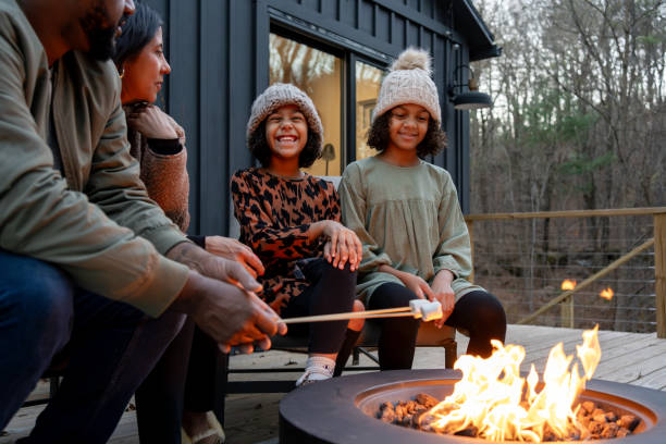 istock family in front of firepit relaxing in mountain house 2186307155