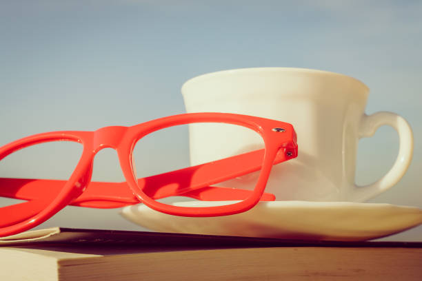 Coffee Cup with Vintage Book and Glasses on a Dark Moody Background