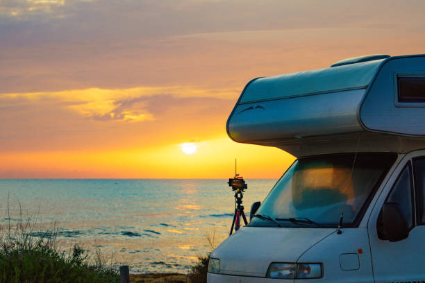 istock Camper and camera on tripod on beach at sunrise 2186314601