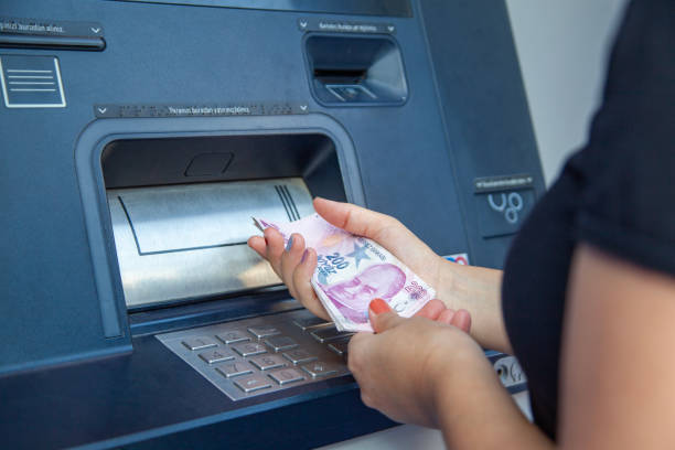 istock Woman using ATM machine, withdrawing money at the ATM. 2186323834