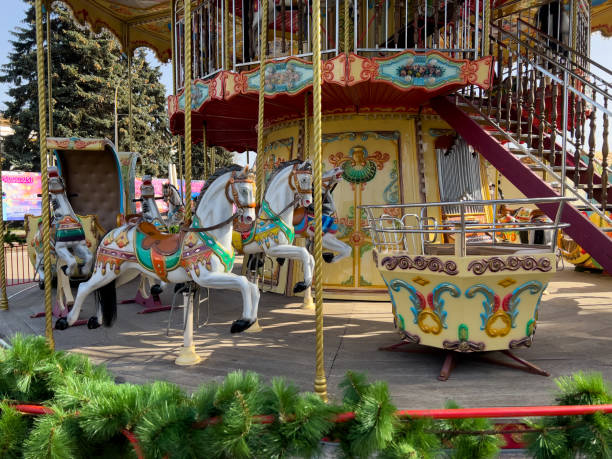 istock A colorful carousel with decorated horses and a two-tier structure stands in a sunny outdoor amusement park. The festive design features intricate patterns and bright colors. 2186326521