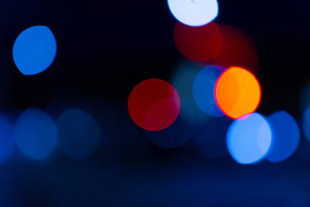 A dynamic bokeh image featuring prominent green and red lights against a dark background, creating a colorful glow.