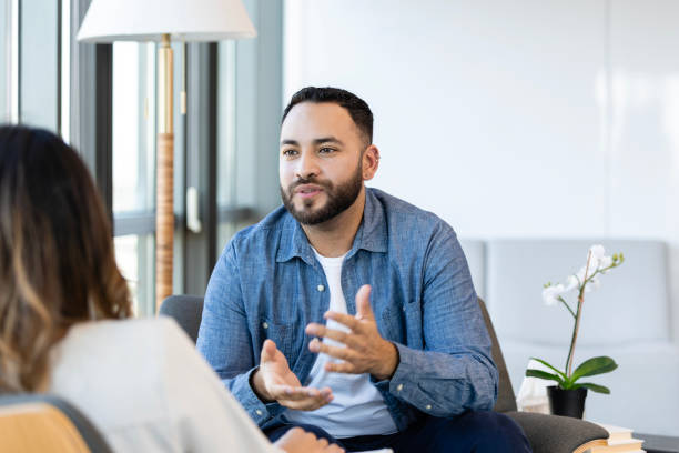 man gestures while talking with therapist - therapie stockfoto's en -beelden