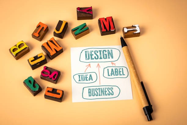 istock DESIGN Concept. Notepad and wooden alphabet letters on a light background 2186333315