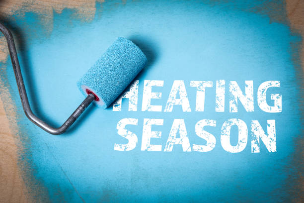 istock Heating Season. Blue paint and paint roller on wooden background 2186333327