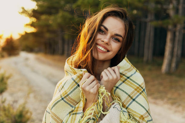 istock smiling woman in plaid blanket outdoors leisure lifestyle 2186334537