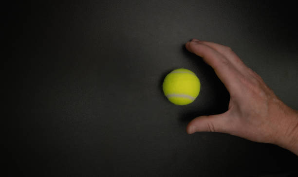 istock Hand catching tennis ball on black background 2186334613