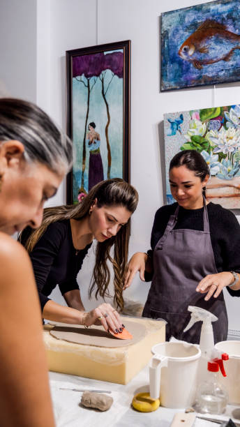 istock In an art studio with an environment adorned with artistic paintings in the background, three beautiful middle-aged artist friends are working on clay shaping at a table 2186335293