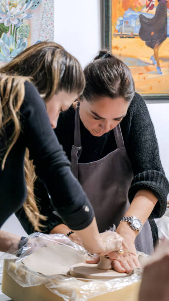 istock In an art studio with an environment adorned with artistic paintings in the background, two beautiful middle-aged artist friends are working on clay shaping at a table 2186335458