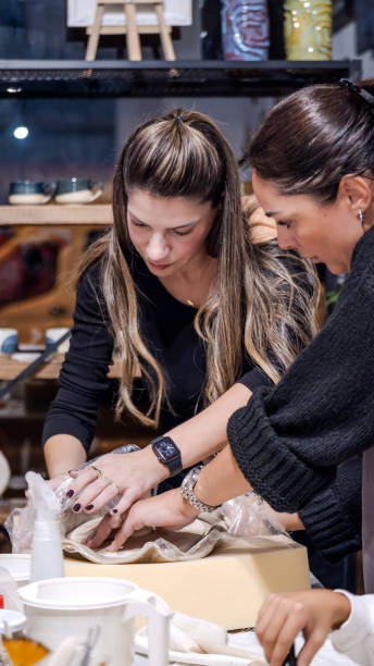 istock In an art studio with an environment adorned with artistic paintings in the background, two beautiful middle-aged artist friends are working on clay shaping at a table 2186335489