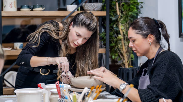 istock In an art studio with an environment adorned with artistic paintings in the background, two beautiful middle-aged artist friends are working on clay shaping at a table 2186335991