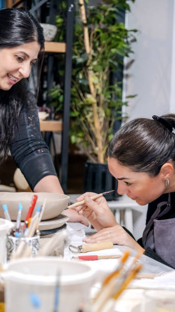 istock In an art studio with an environment adorned with artistic paintings in the background, two beautiful middle-aged artist friends are working on clay shaping at a table 2186336710
