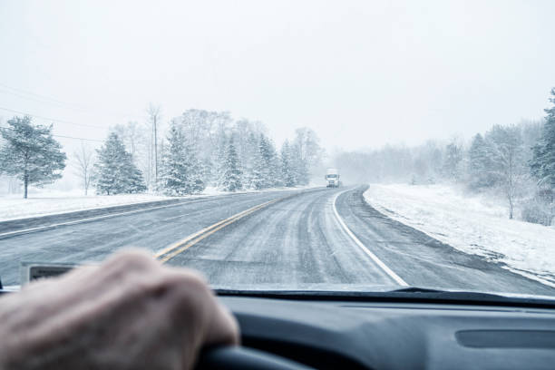istock Distant Semi Truck Approaching on Winter Blizzard Rural Highway 2186338516