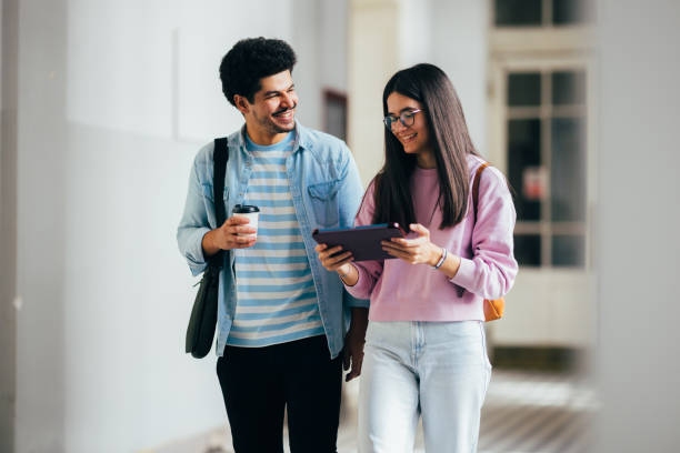 istock Young Adults Smiling While Walking in a Bright Hallway 2186344143