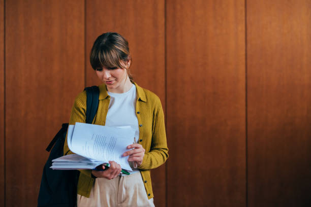 Young Woman Reviewing Documents Against Wooden Panel Background