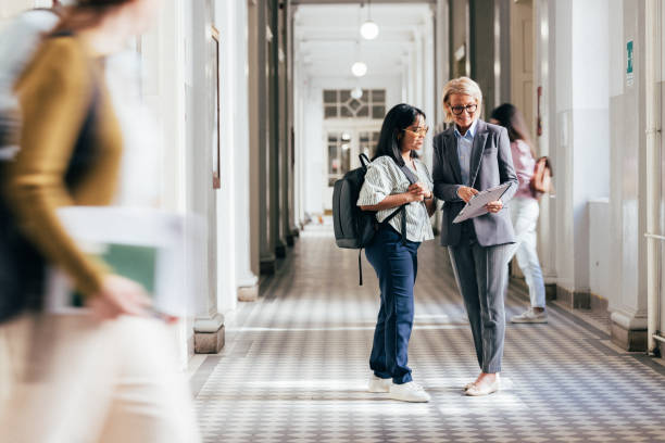 istock Teacher and Student Discussing Work in a School Hallway 2186344303