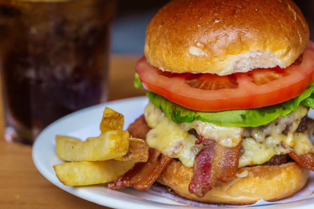 istock Delicious Cheeseburger with Bacon and Fries on a White Plate 2186360567