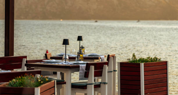 istock A cozy table at a waterfront cafe overlooking the bay, set for a romantic and tranquil dining experience at sunset. 2186362229
